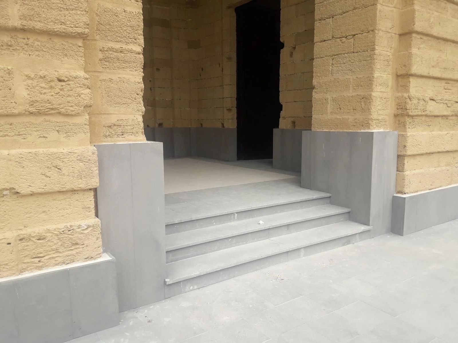 Exterior application: grey stone bases beside the steps of an arcade