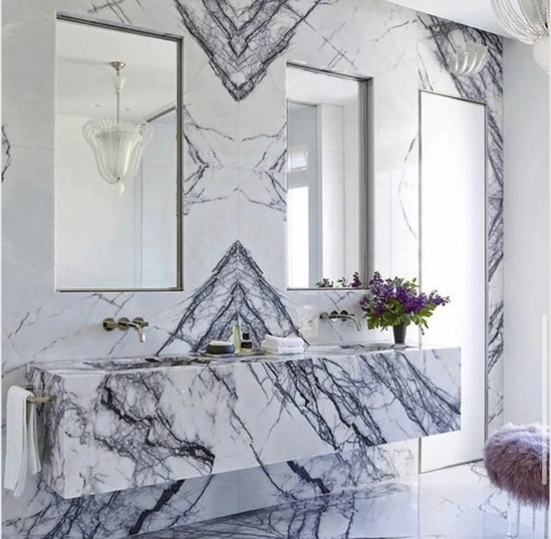 Book-matched veining composed across a marble vanity and the wall above it