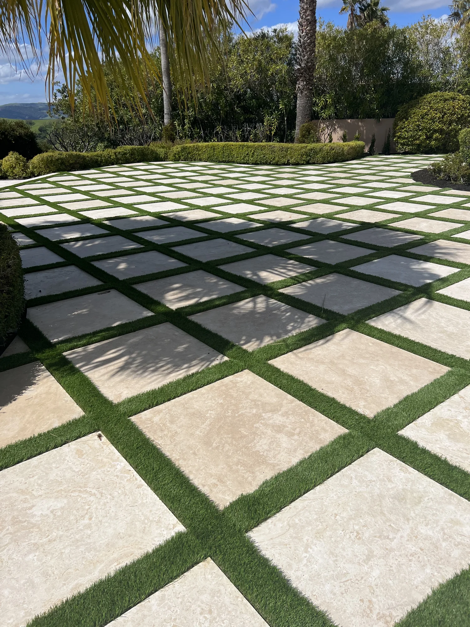 Square pavers and grass joints at the edge of a planted terrace