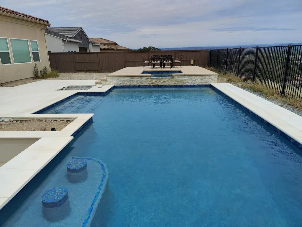 Pool and raised spa showing the light coping along their water edges