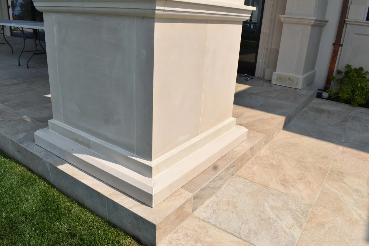 Layered square column base meeting the terrace paving