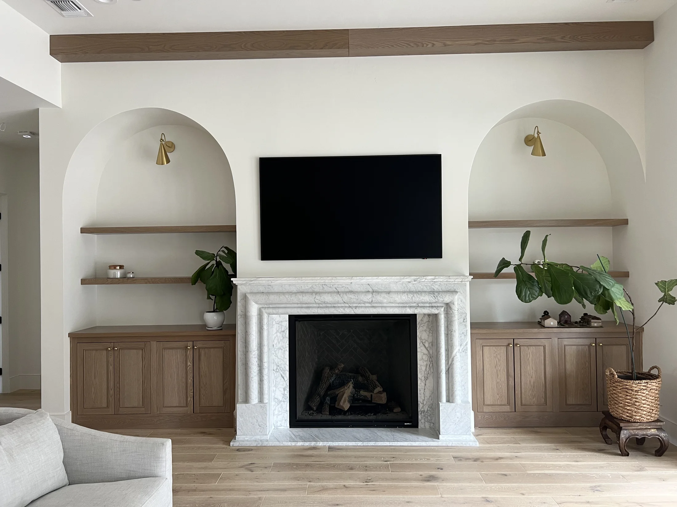 Light fireplace surround between built-in shelves and cabinets