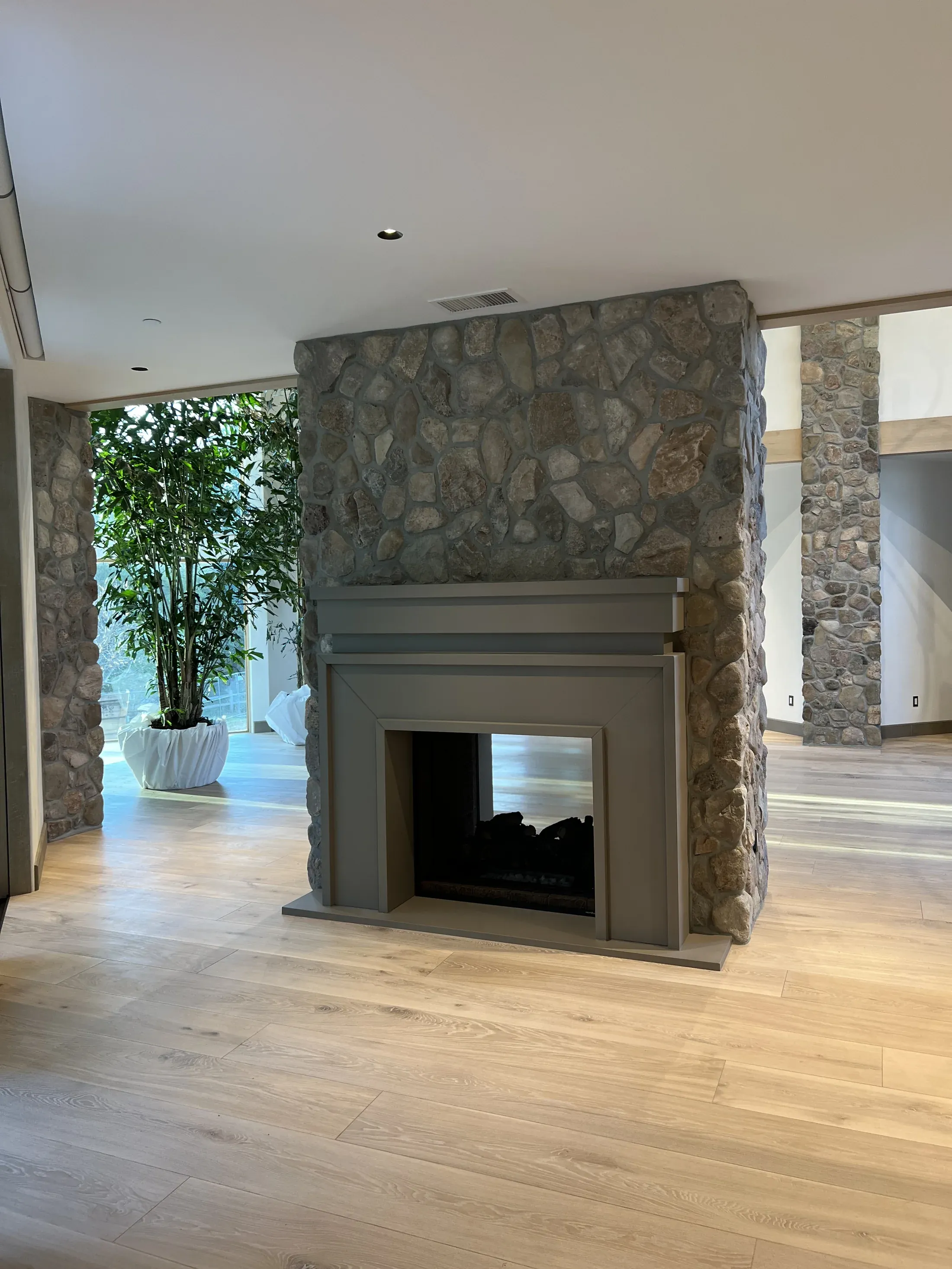Straight-edged mantel within a stone-clad room divider