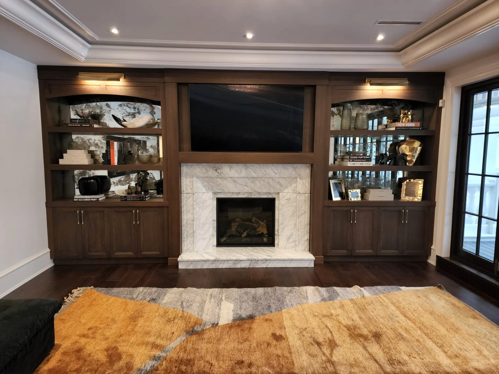 Veined stone surround between dark timber cabinets