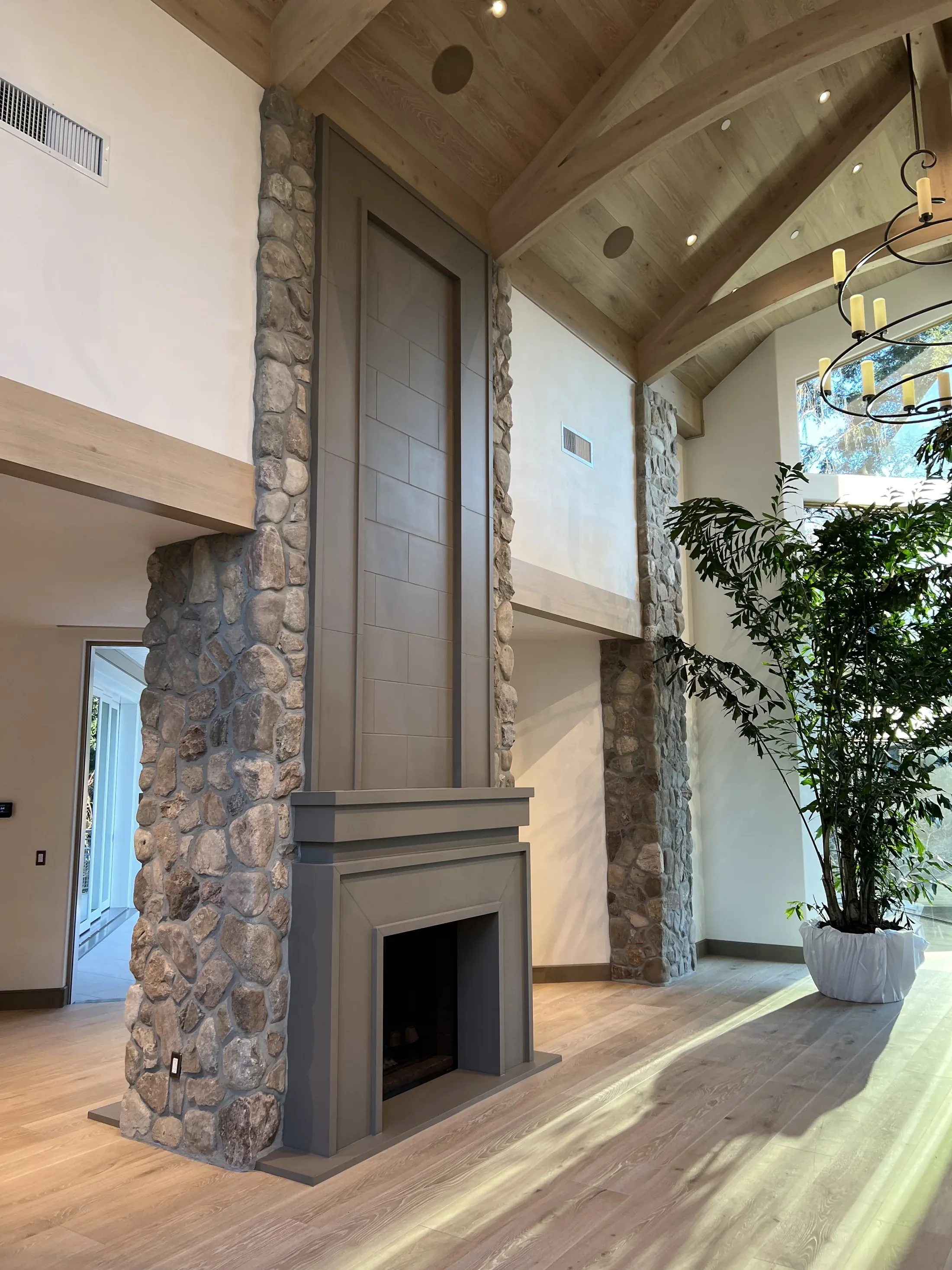 Paneled mantel and overmantel against a full-height stone wall