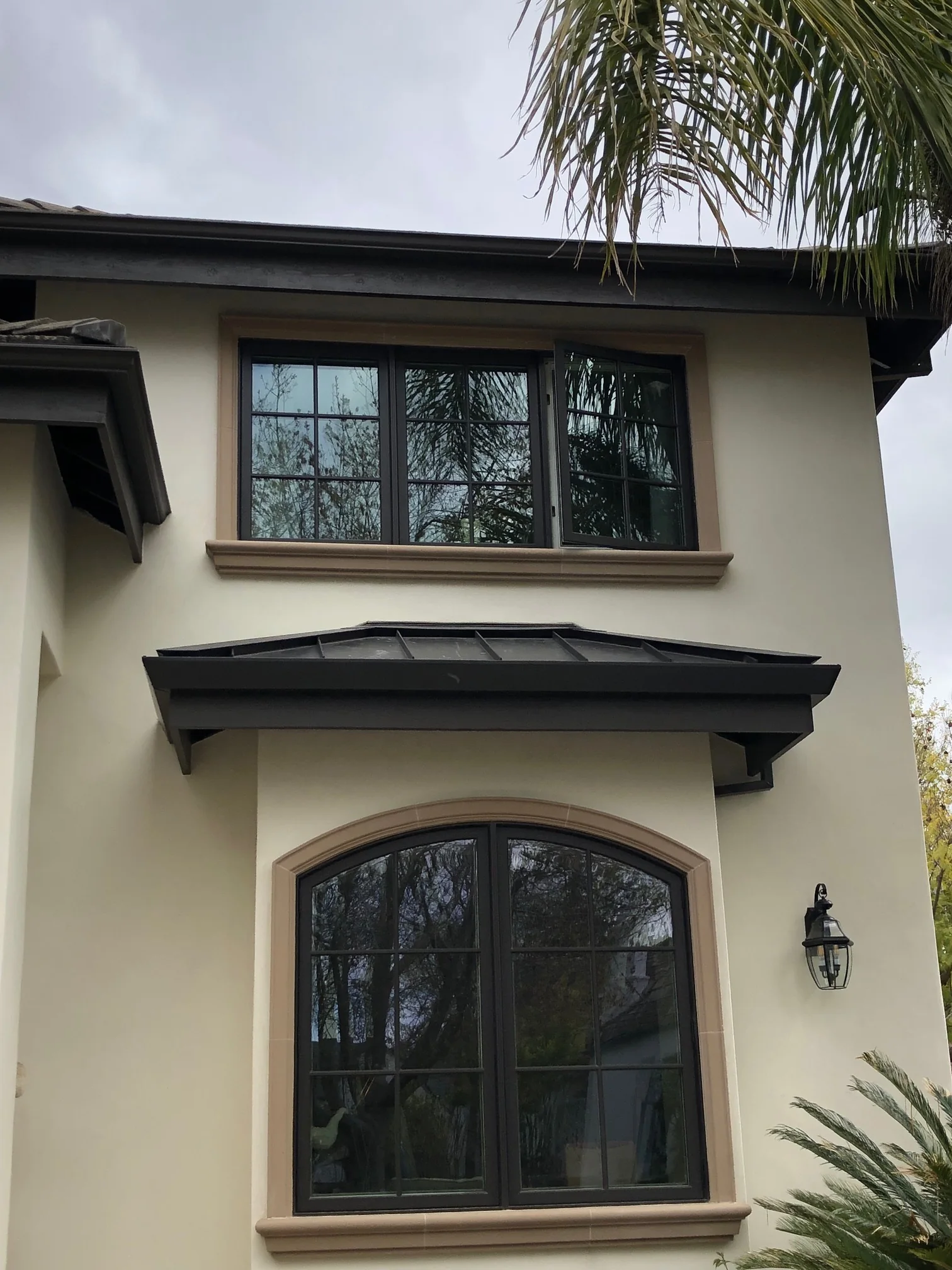 Projecting dark header above the lower arched window