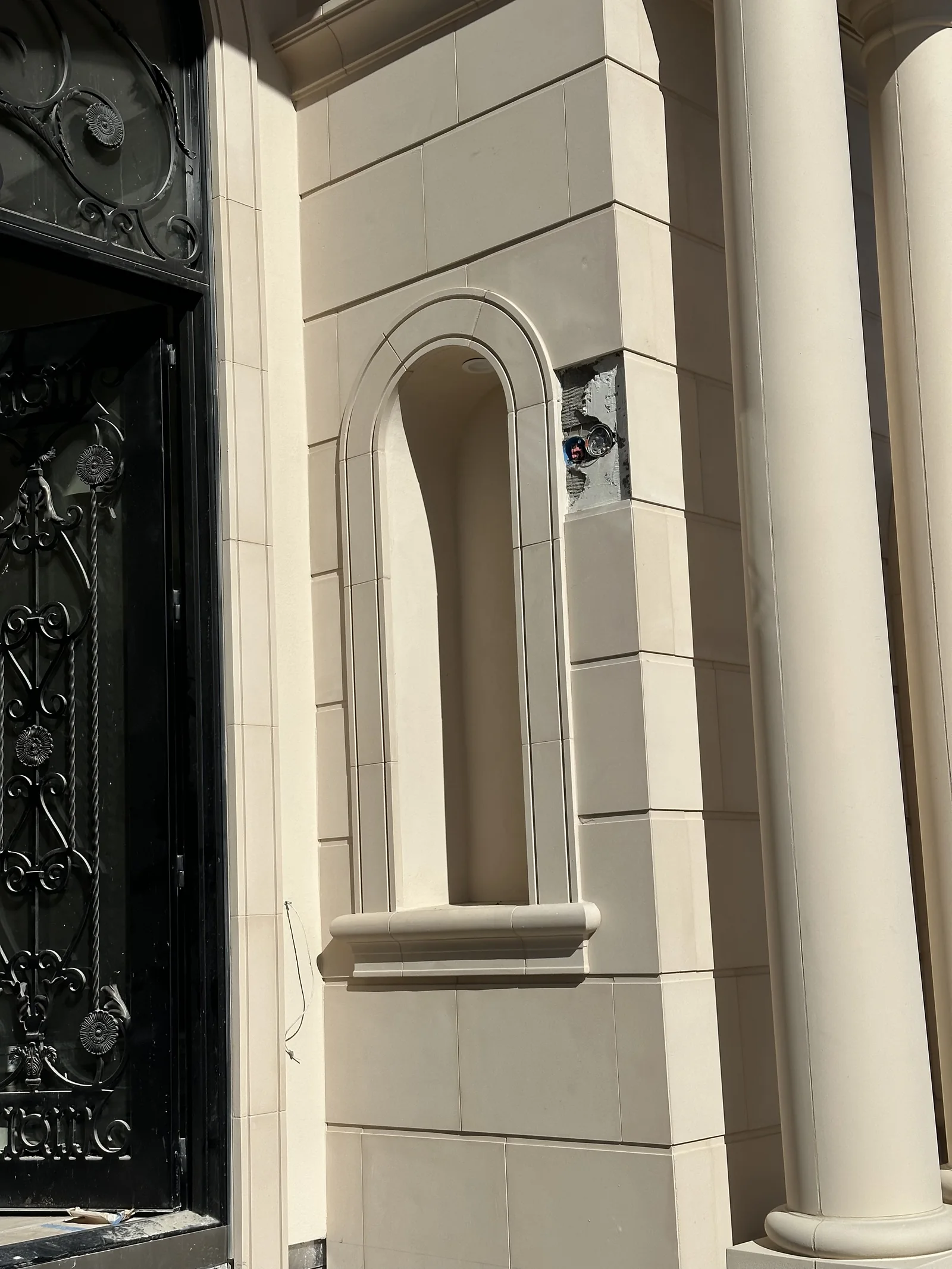 Rusticated wall panels and a moulded arched window surround