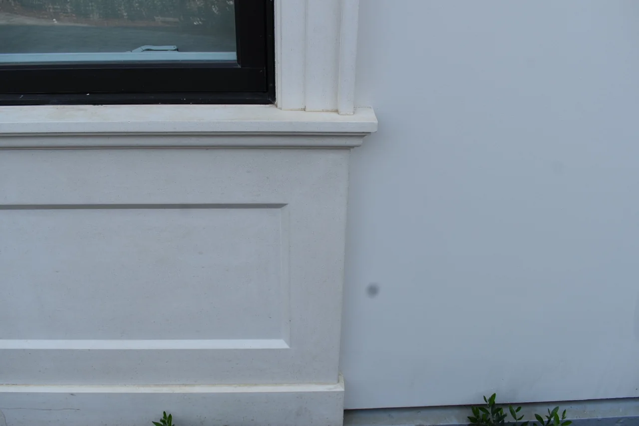 Projecting window sill above a recessed rectangular wall panel