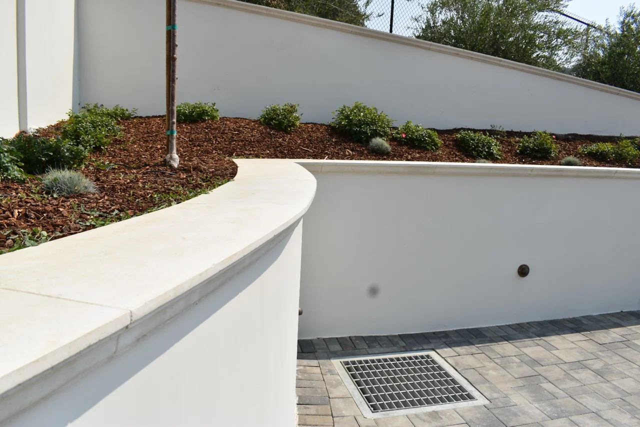 Cast caps following a curved retaining wall