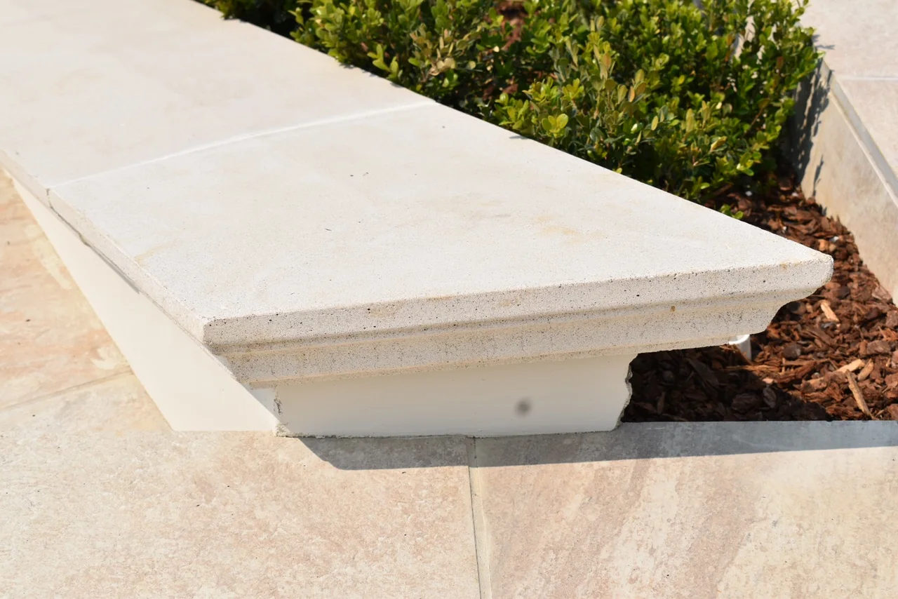 Close view of a wall cap's projecting edge and moulded underside