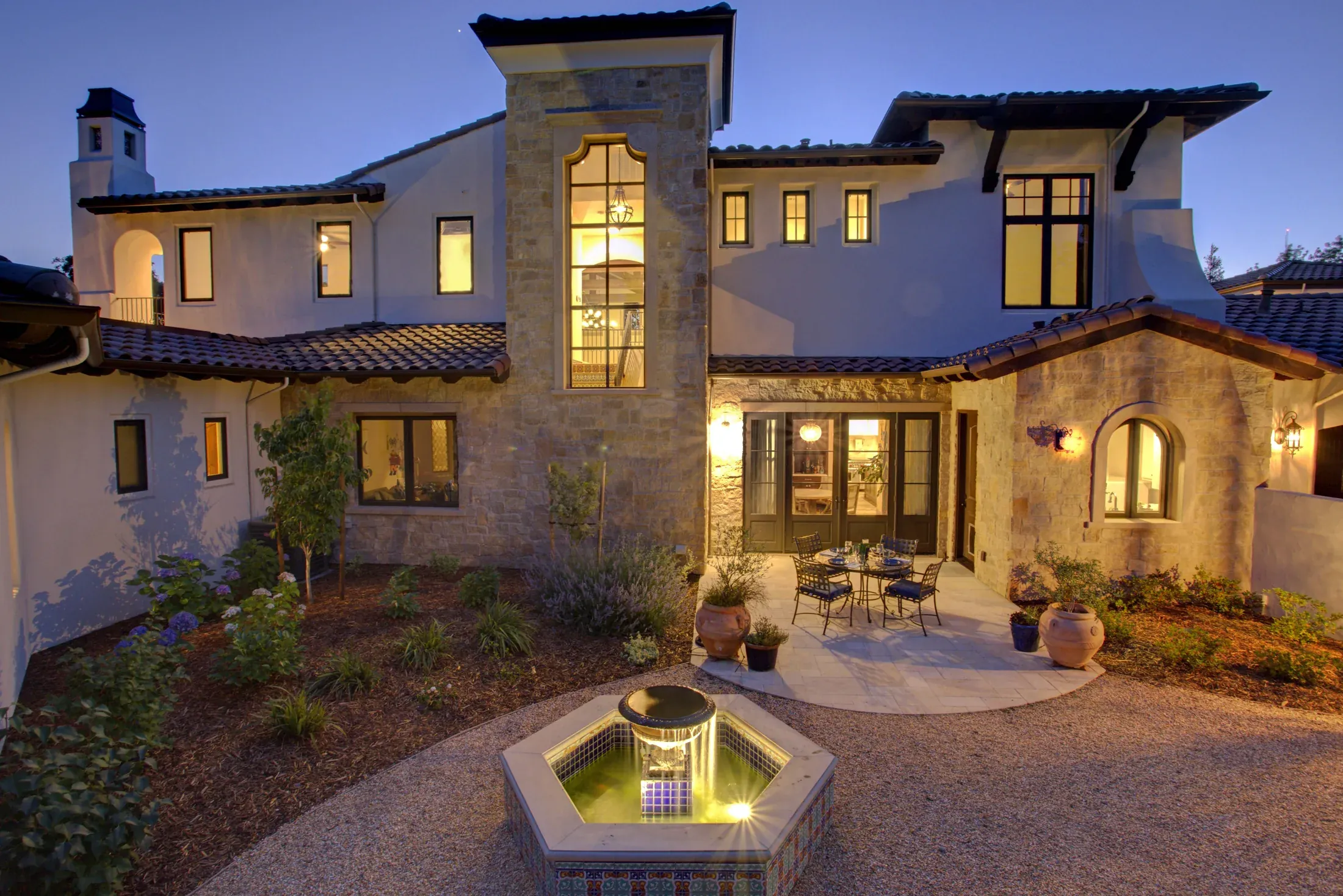 Stone residence and courtyard at dusk